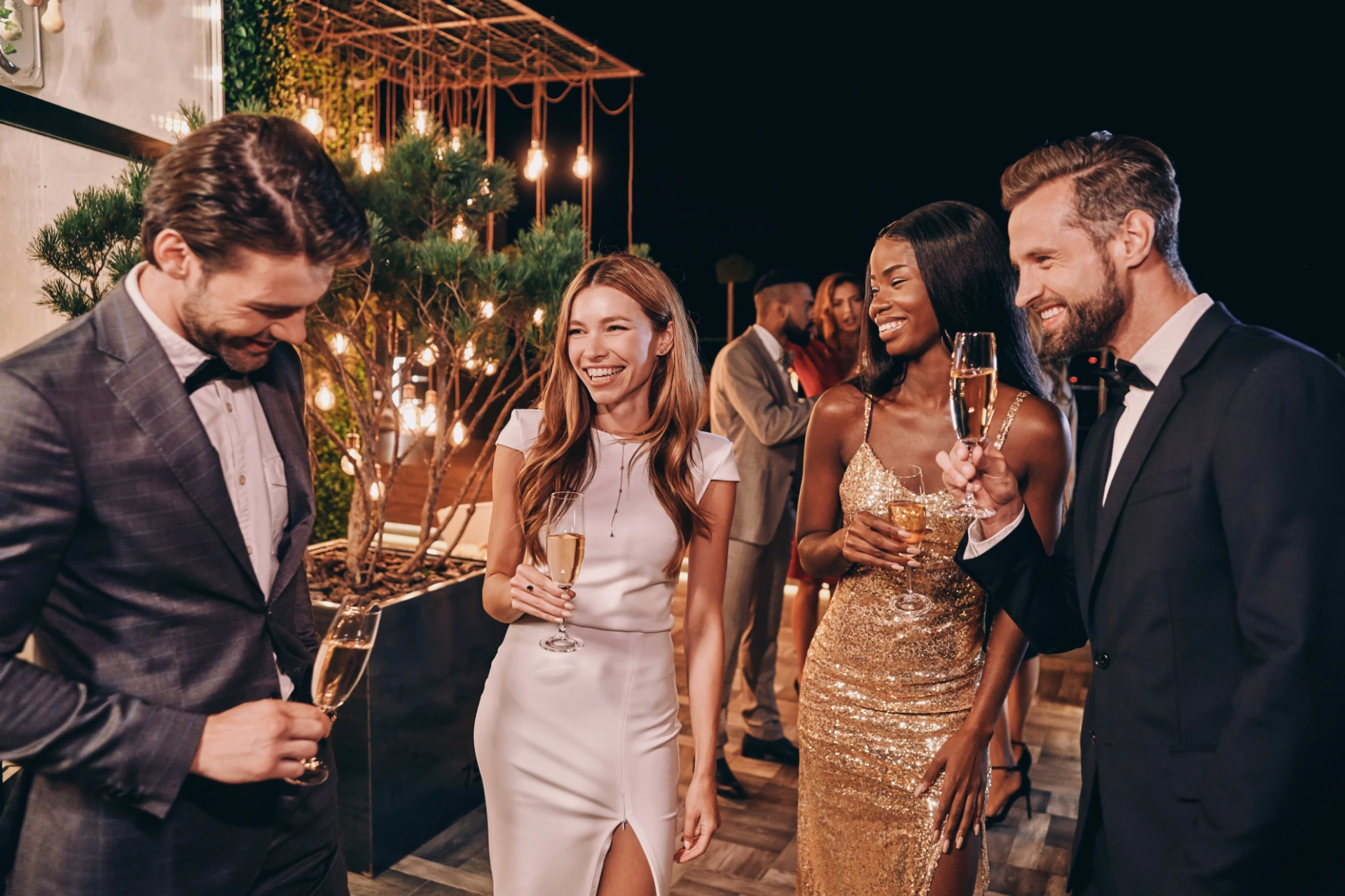 Group of beautiful people in formalwear communicating and smiling while spending time on luxury party