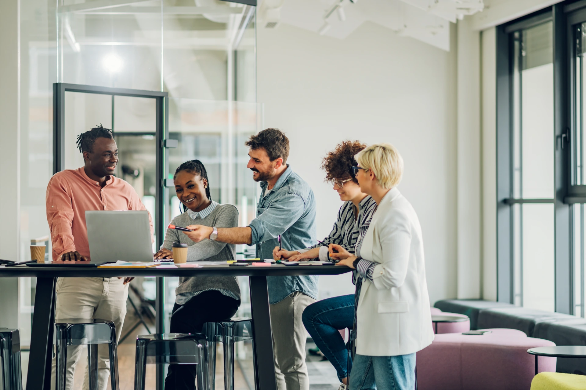 Diverse employees gathered in the office having fun during brainstorming while discussing new ideas for their new project. Multiracial coworkers gather in boardroom discuss ideas in group at briefing.