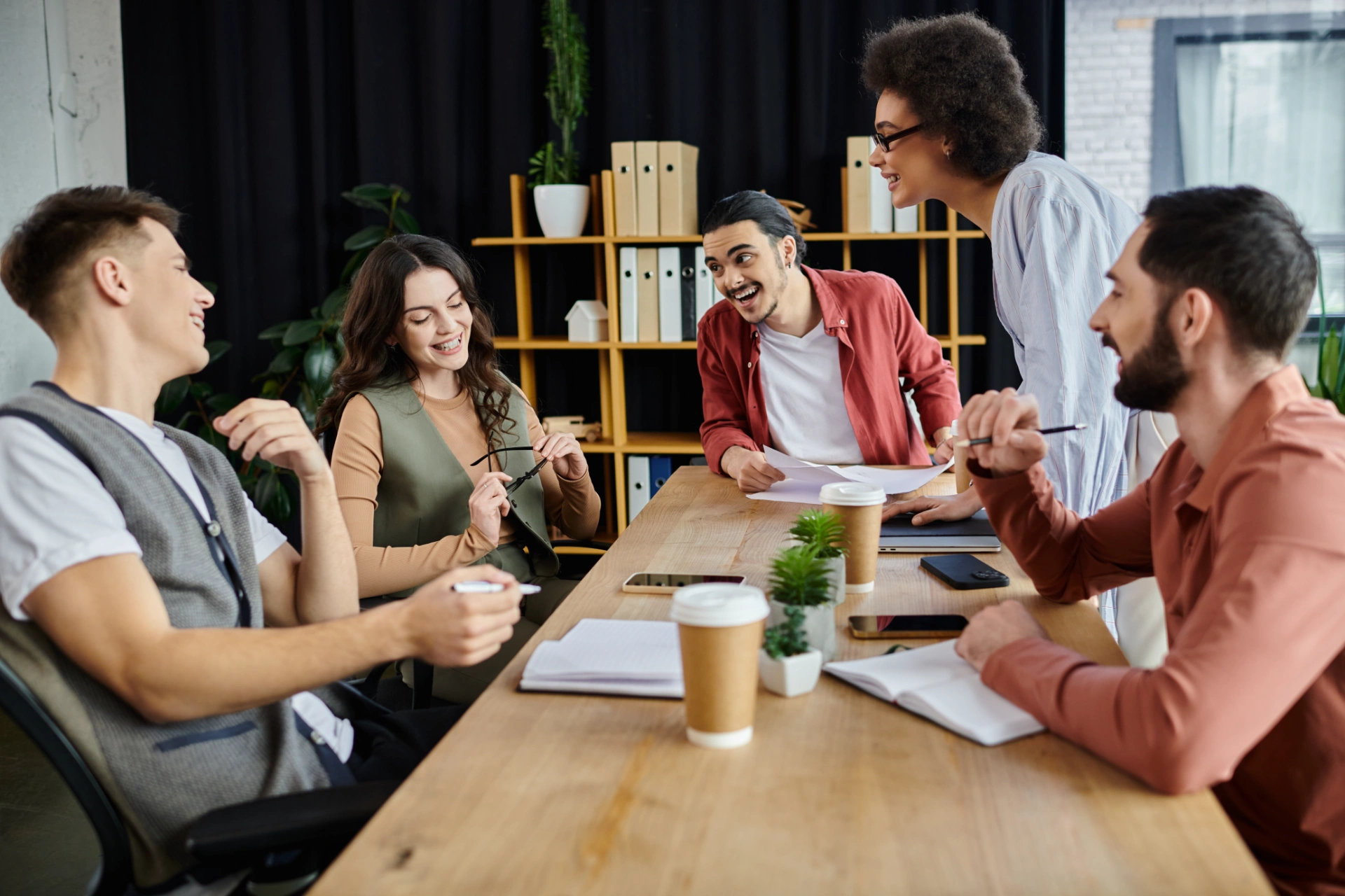 Team members share smiles and thoughts amid challenging conversations.